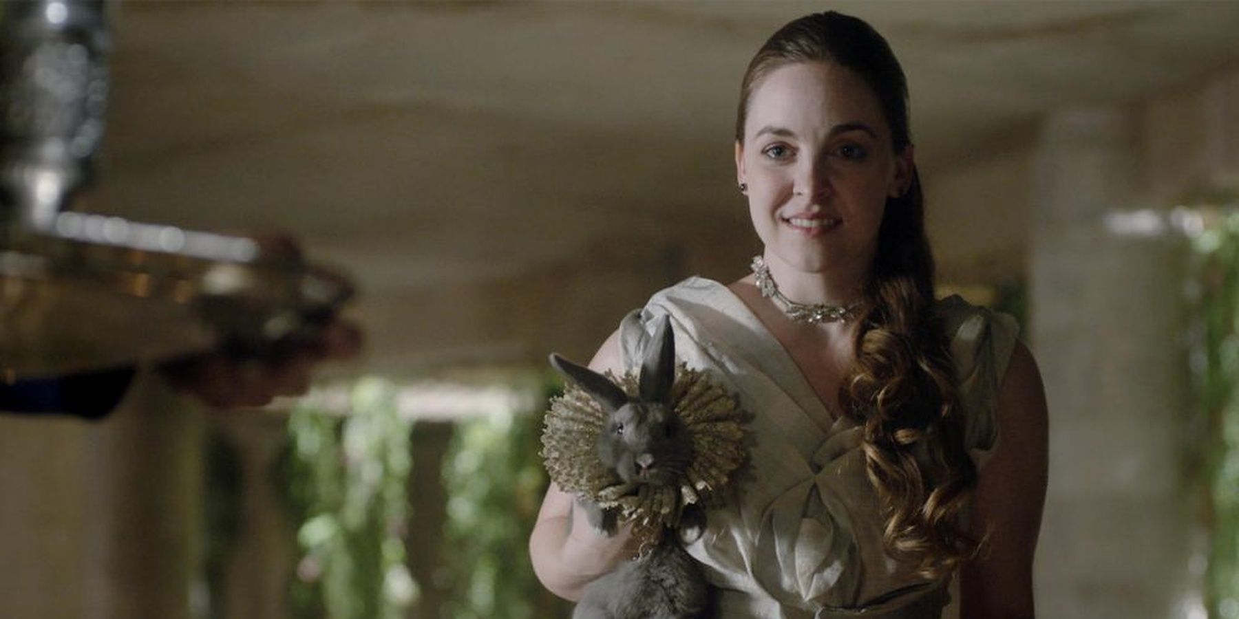 Fen appears apprehensive while holding a bunny in the palace in The Magicians