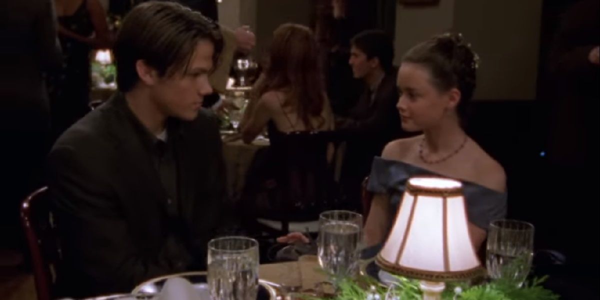 Dean and Rory sitting at a table at the Chilton school. dance on Gilmore Girls