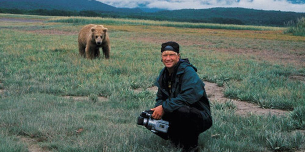 Timothy Treadwell kneels in front of a grizzly bear from Grizzly Man