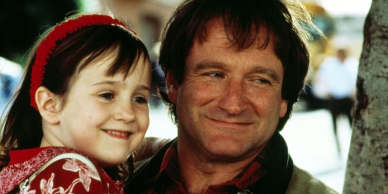 Robin Williams smiling and holding Mara Wilson in Mrs. Doubtfire