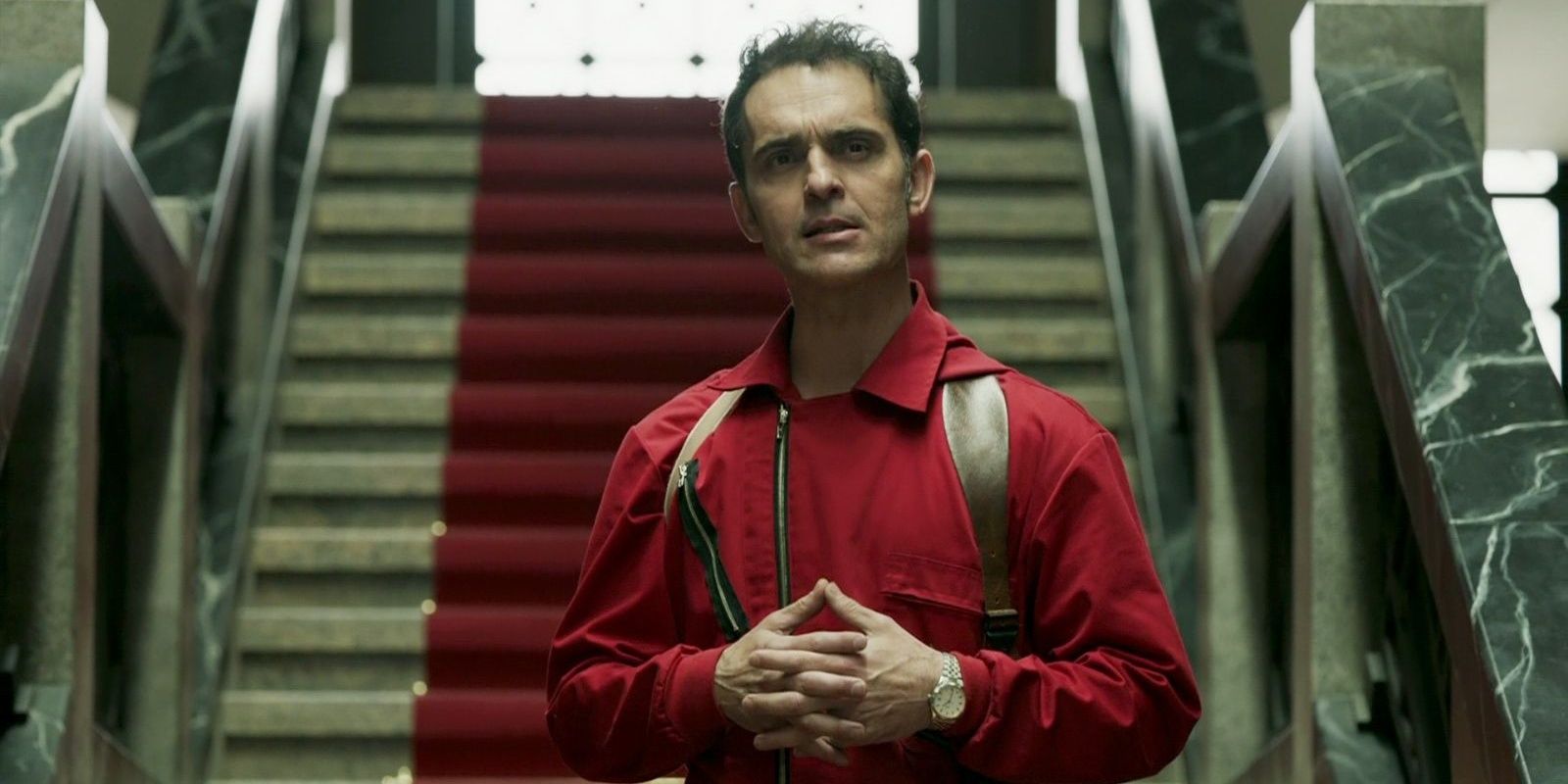 Berlin standing in front of a staircase in Money Heist