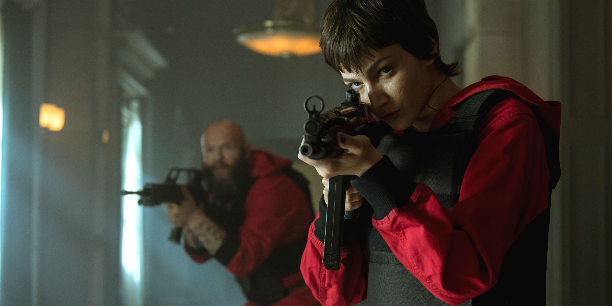 An image of Tokyo holding a gun in the foreground with Helsinki following her in the background in the show Money Heist.