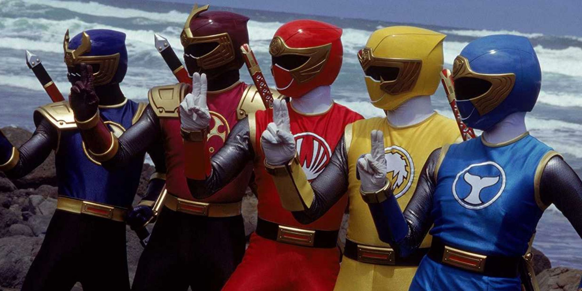 Five members of the Power Rangers Ninja Storm team stand together in uniform on the beach
