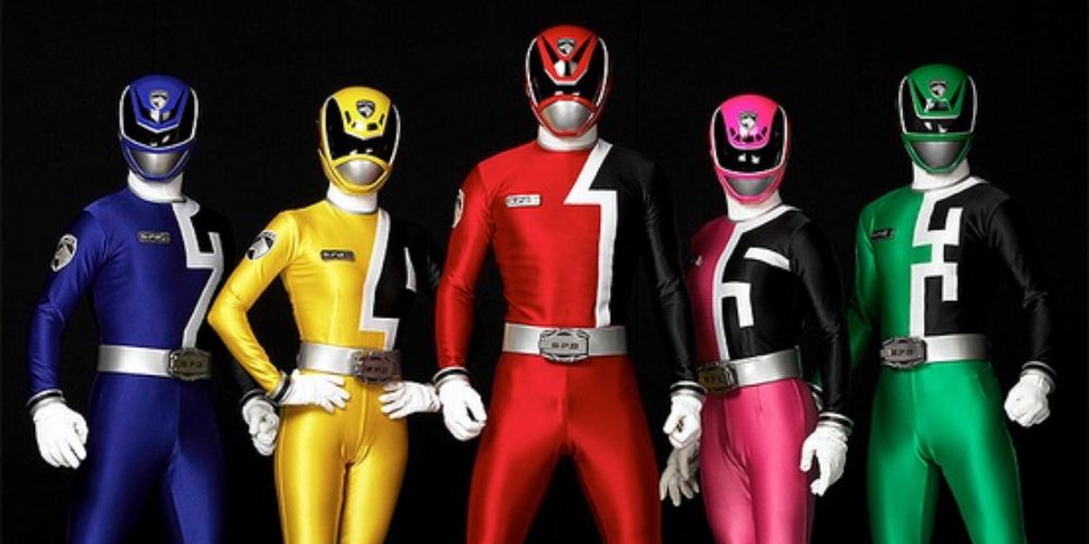 The five SPD Power Rangers stand in uniform against a black background