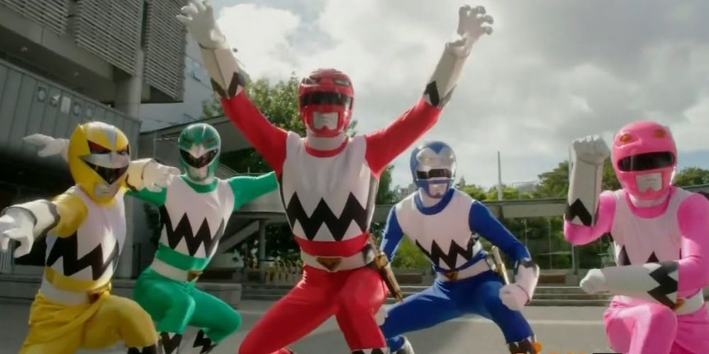 The Lost Galaxy Power Rangers team crouches in uniform in the middle of a fight