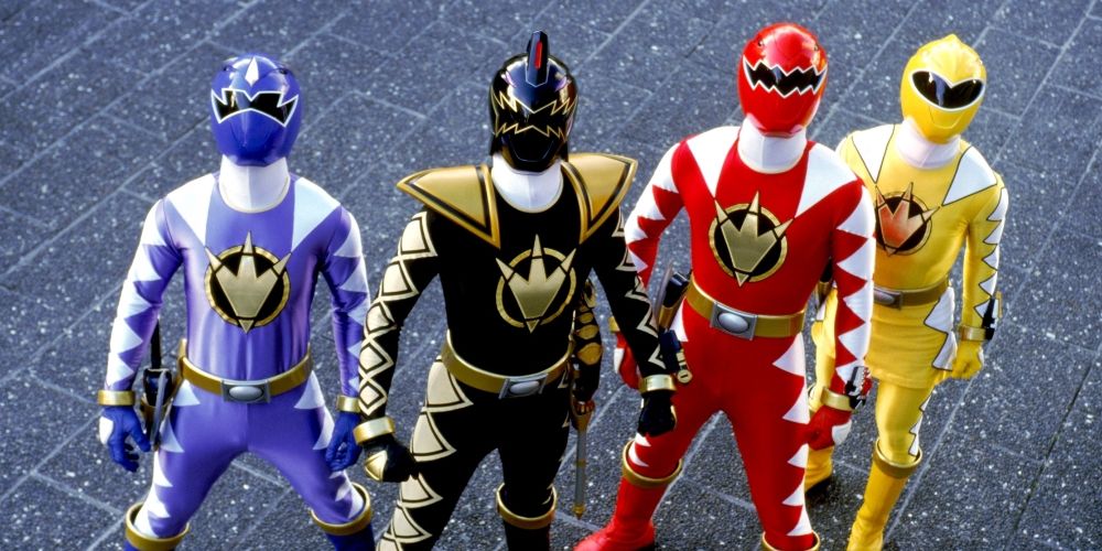 The Blue, Black, Red, and Yellow Dino Thunder Power Rangers stand together in uniform, looking up at a threat