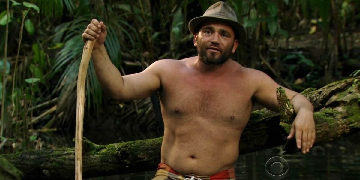Russell Hantz leaning against a tree
