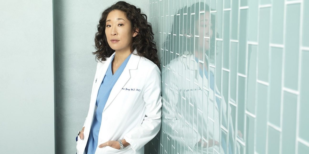 Cristina Yang parada perto de uma parede em Grey's Anatomy.