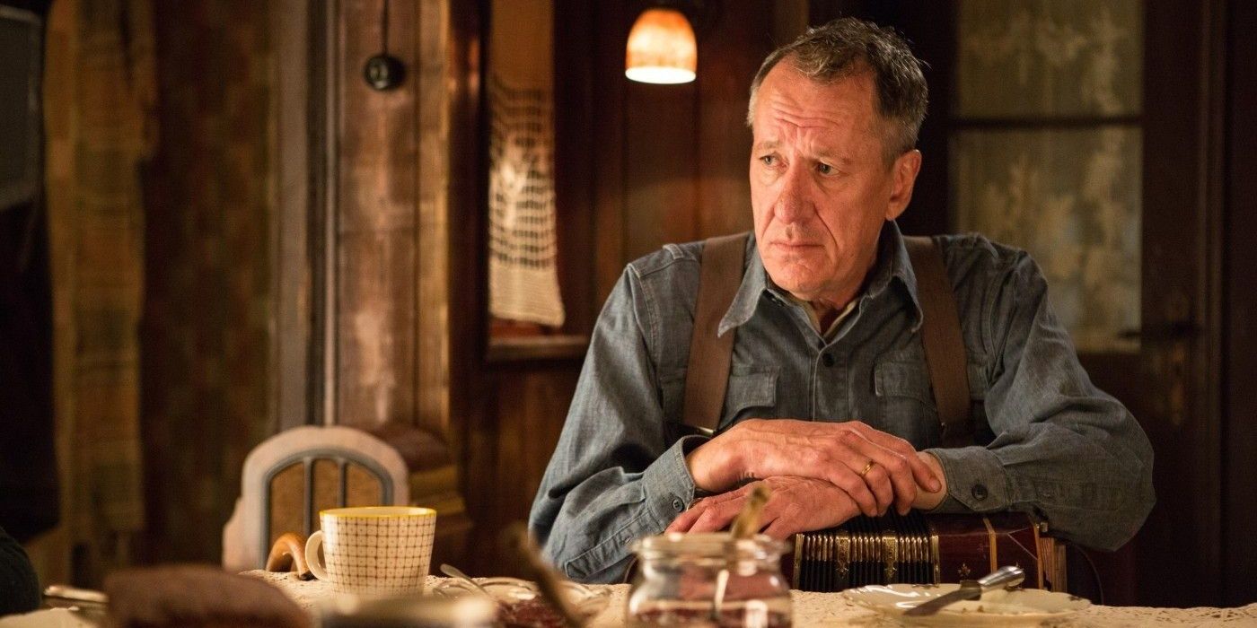 Geoffrey Rush looking concerned while sitting at a table in The Book Thief 