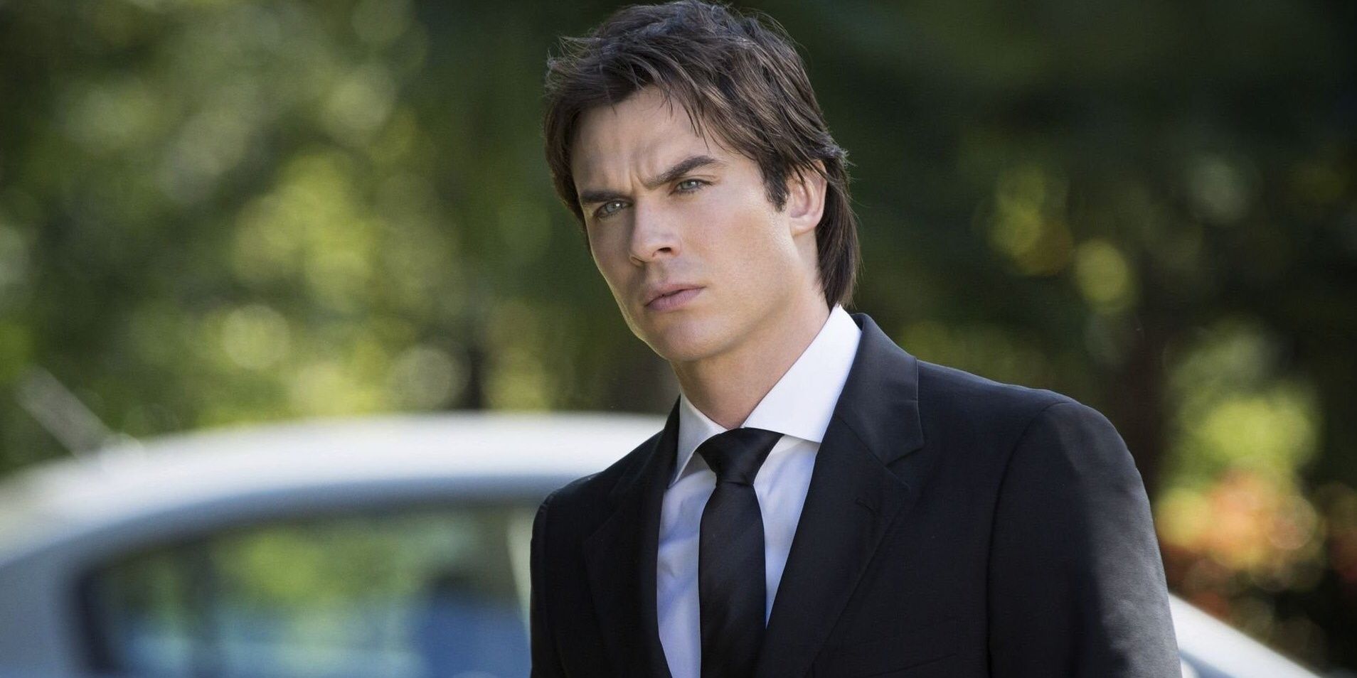 Damon in a suit looking to the distance in The Vampire Diaries.