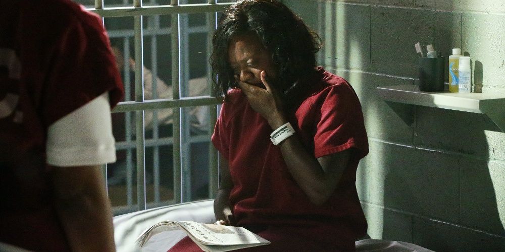 An inmate in prison cries while reading the newspaper in How To Get Away With Murder