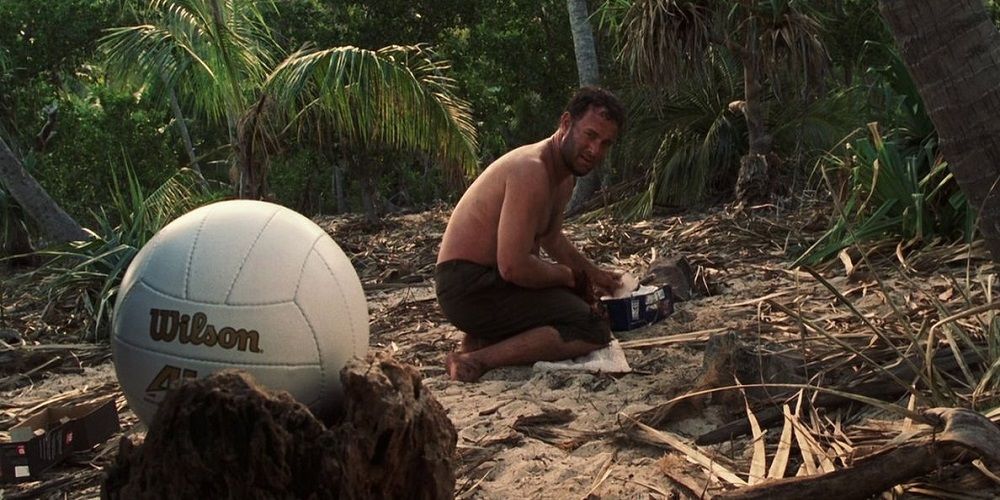 Chuck looks at the ball sat on the sand 