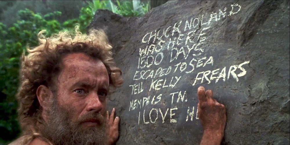 Tom Hanks writes a message on a rock in Castaway 