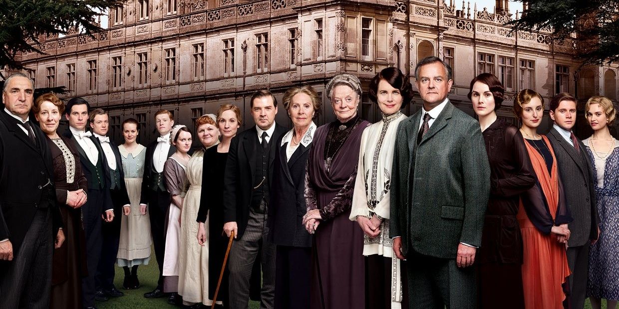 A photo of the cast in front of Downton Abbey