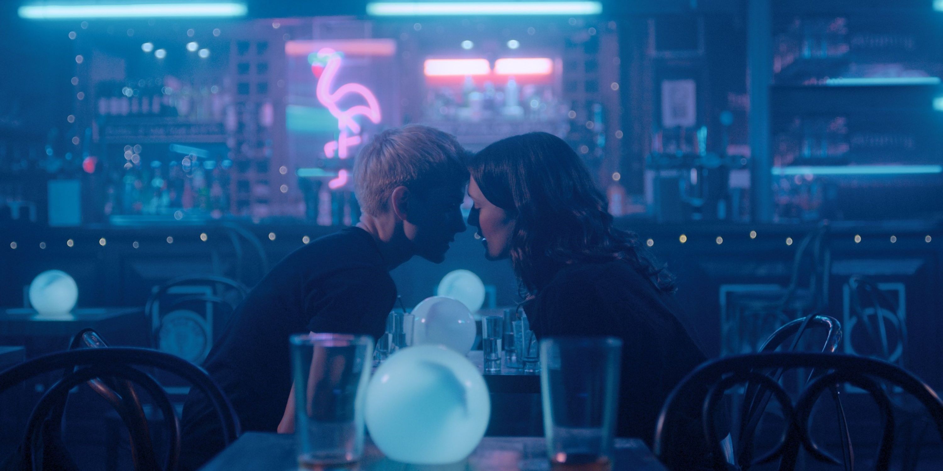 Two characters kissing each other in an empty bar in Feel God