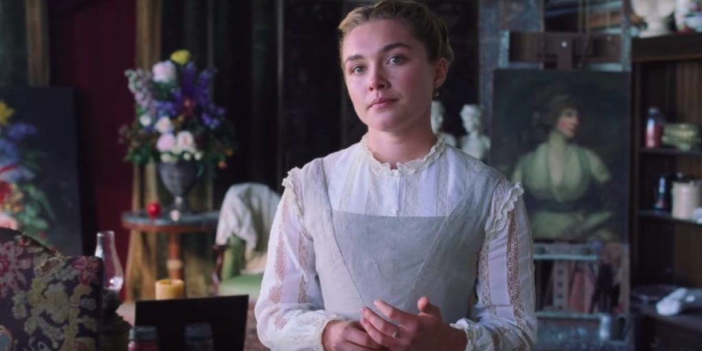 Florence Pugh as Amy March in Little Women stands in a room and smiles very slightly.