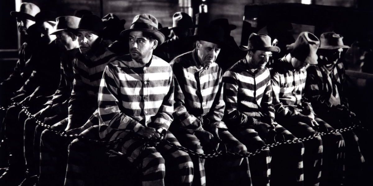 Paul Muni looks on while chained to a line of other prisoners in I Am a Fugitive from a Chain Gang