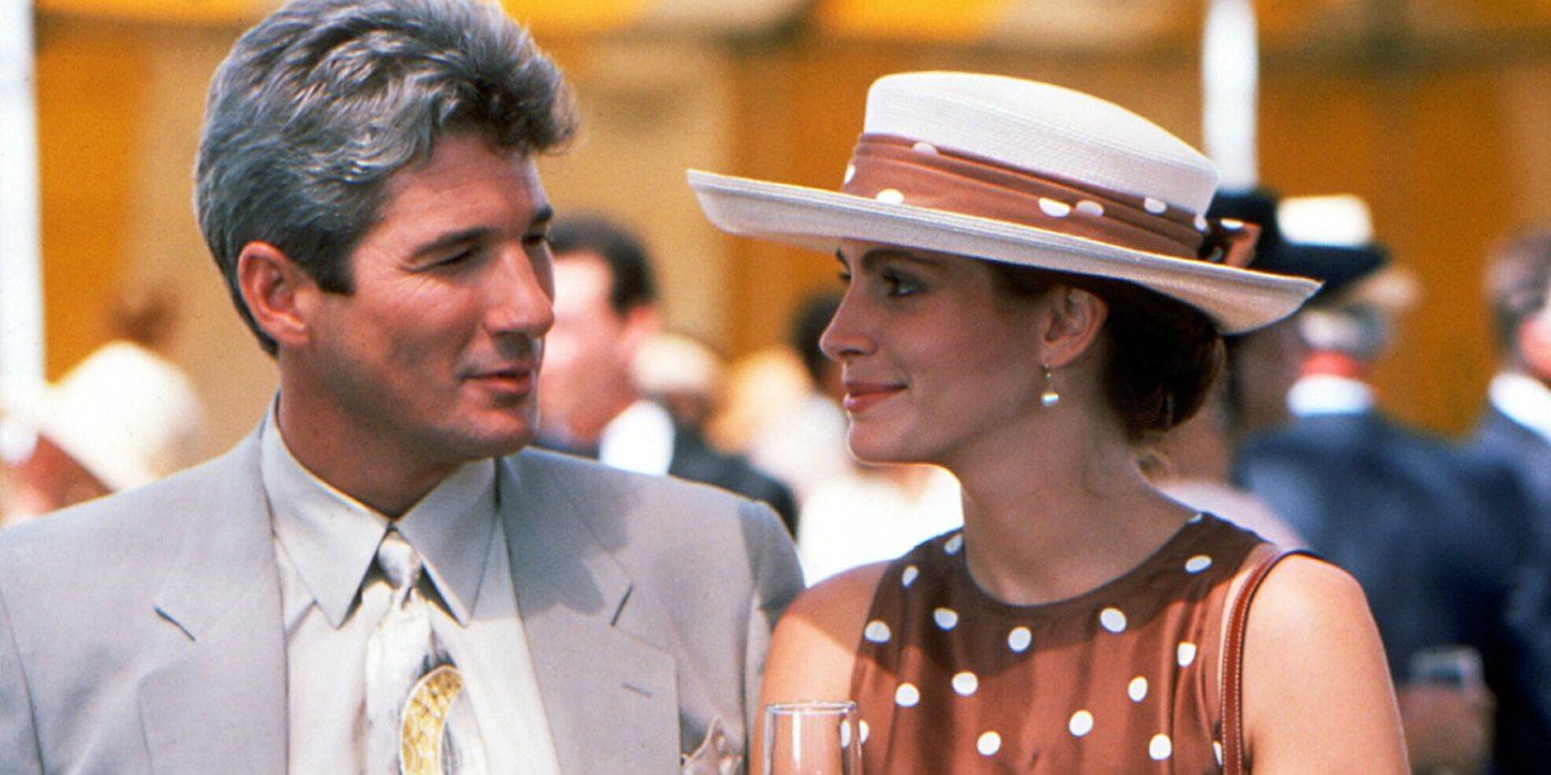 Edward and Vivian smile at one another over a glass of champagne outside in Pretty Woman