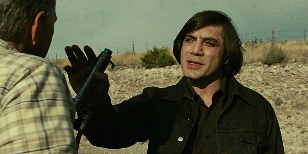 Anton holding up his weapon in front of a man in No country for old men.