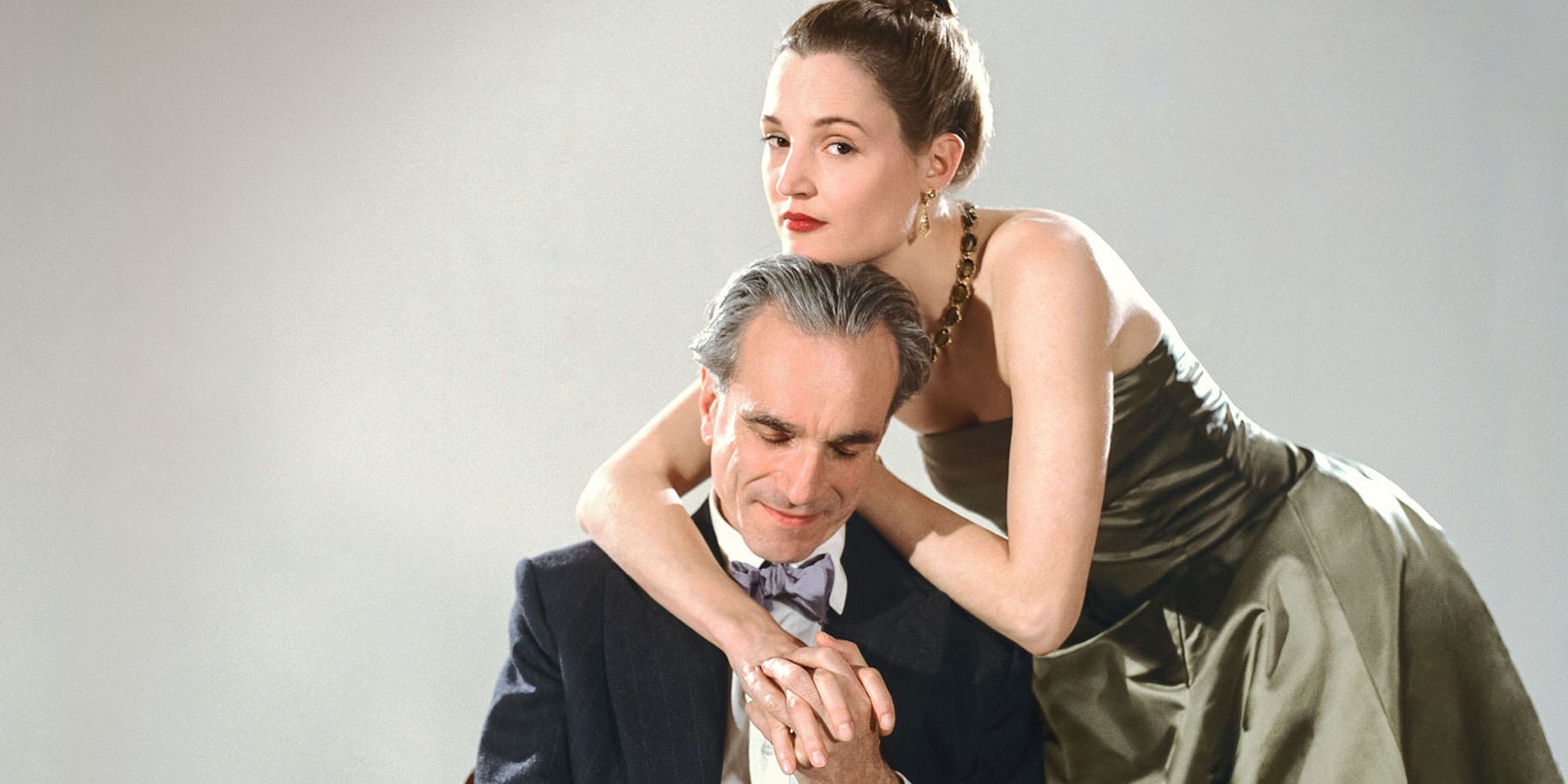 A woman rests herself on a man's shoulders in Phantom Thread