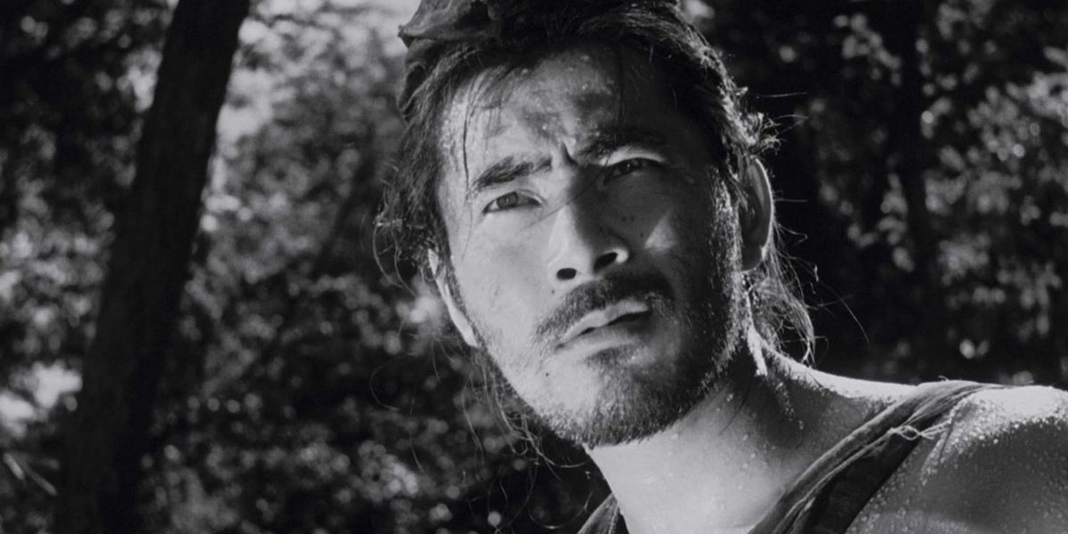 A man squinting while on a forest in Rashomon.