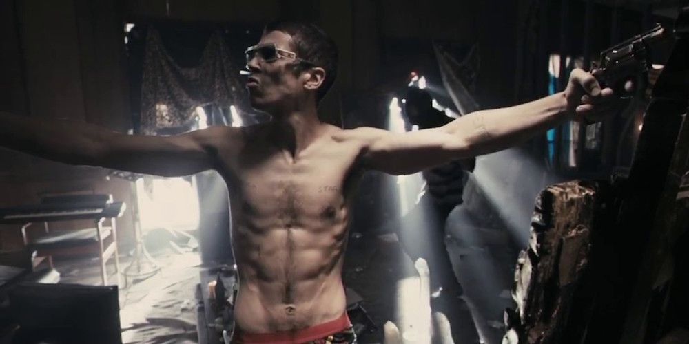 Johnny Quid in RocknRolla shirtless and holding a gun