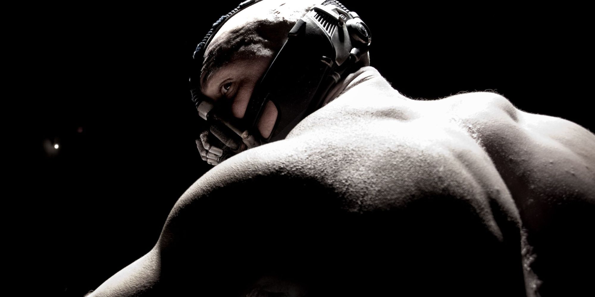 Bane looks behind his shoulder in The Dark Knight Rises