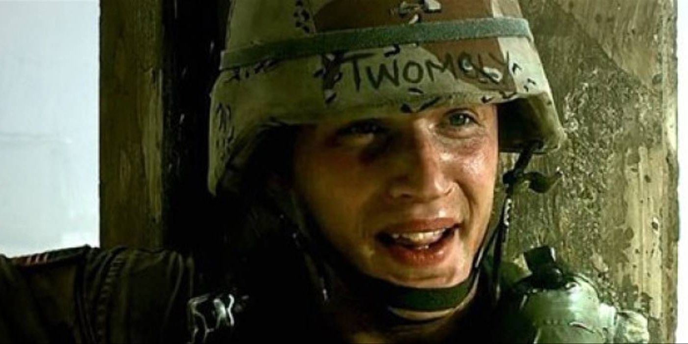 Screencap of Tom Hardy as SPC Lance Twombly in Black Hawk Down. Twombly is taking cover next to a pillar, with his name written on his DBDU-covered helmet. 