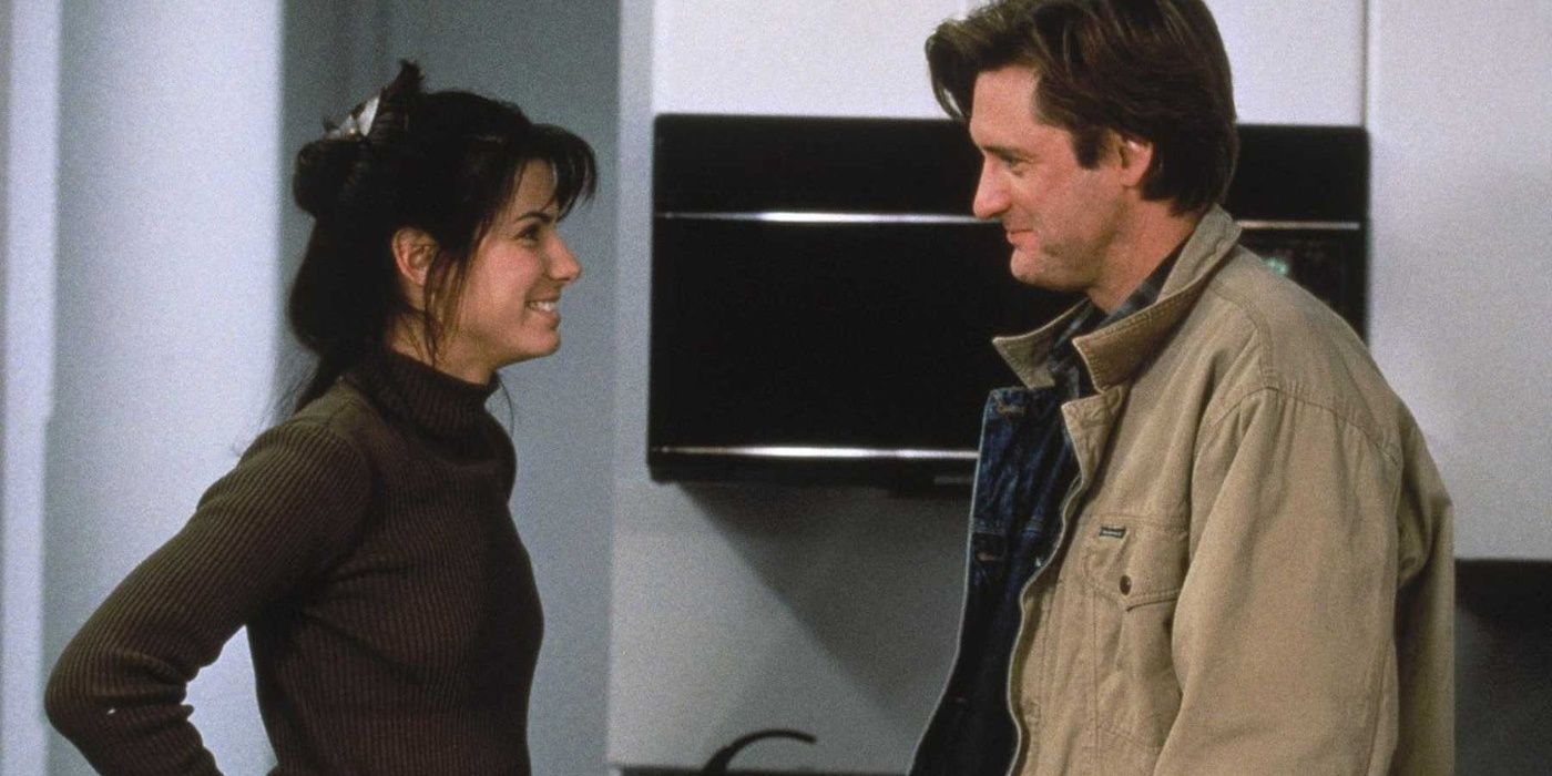 Sandra Bullock and Bill Pullman smiling at each other in While You Were Sleeping