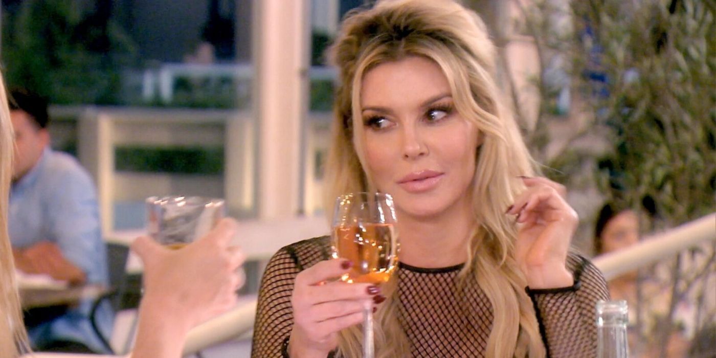 Brandi Glanville drinking a glass of wine with Denise Richards on RHOBH