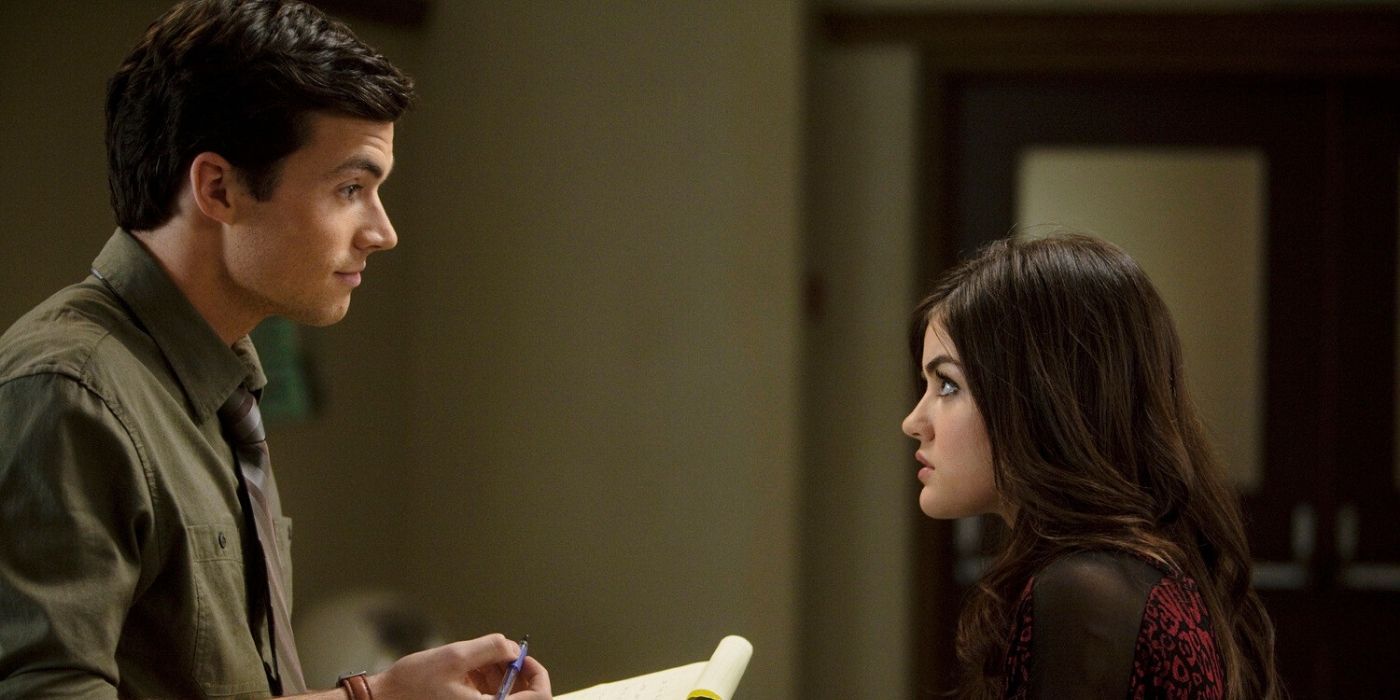 Ezra segurando um bloco de notas e olhando para Aria com expectativa enquanto ela parece surpresa em Pretty Little Liars