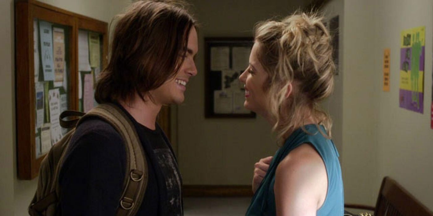 Caleb e Hanna rindo um com o outro no corredor da escola em Pretty Little Liars