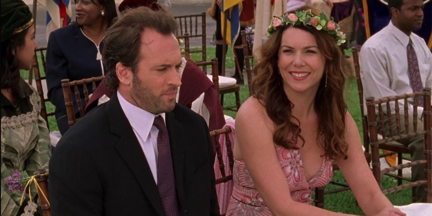 Luke and Lorelai smilng at a wedding on Gilmore Girls
