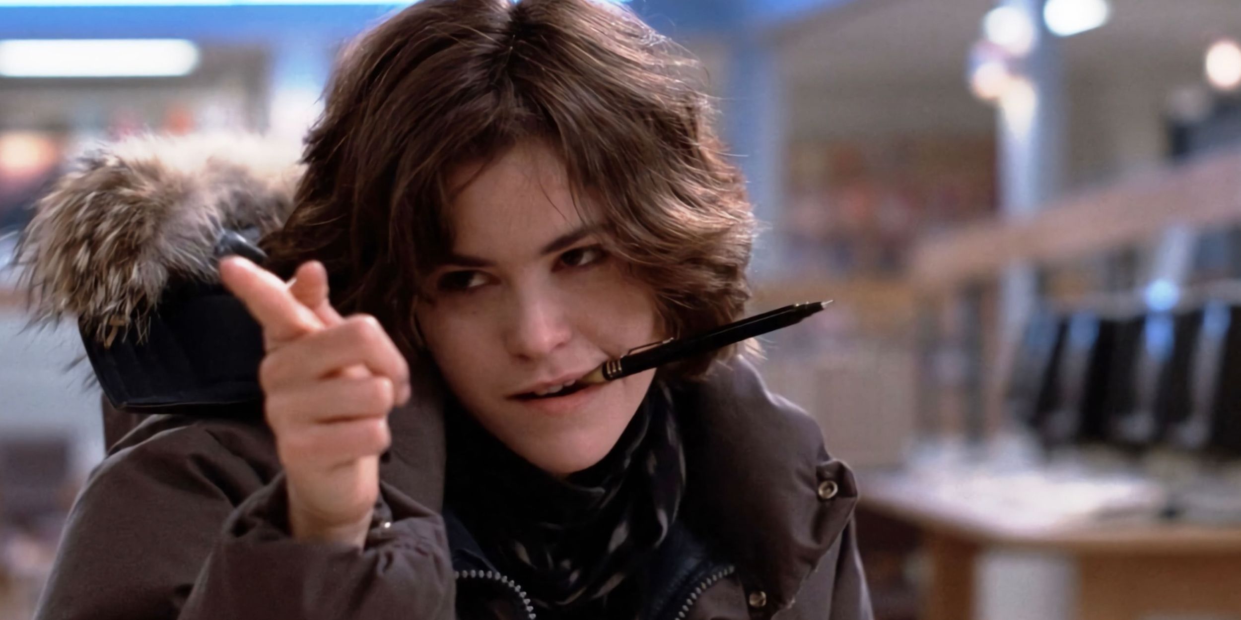 Allison points with one hand while holding a pen in her mouth in The Breakfast Club