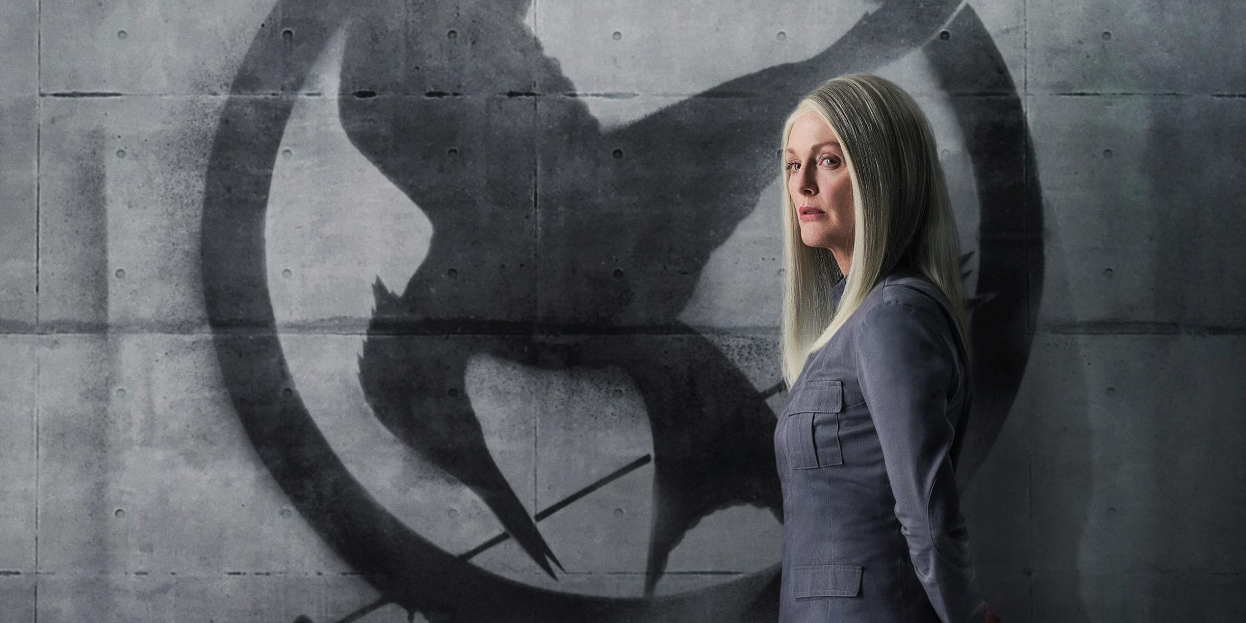 President Alma Coin in front of the Mockingjay symbol in a promotional image for the Hunger Games franchise