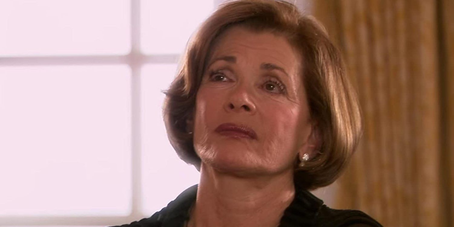 Lucille glares in front of a window in Arrested Development.