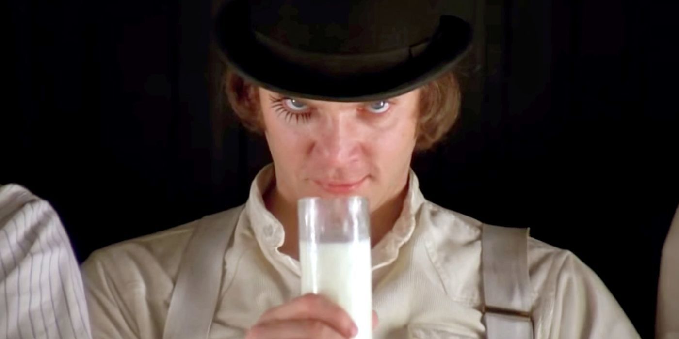 Malcolm McDowell holding a glass of milk while staring at the camera as Alex in A Clockwork Orange