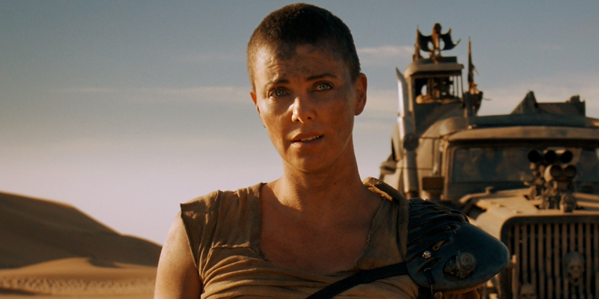 Furiosa is standing in front of a truck in Mad Max Fury Road