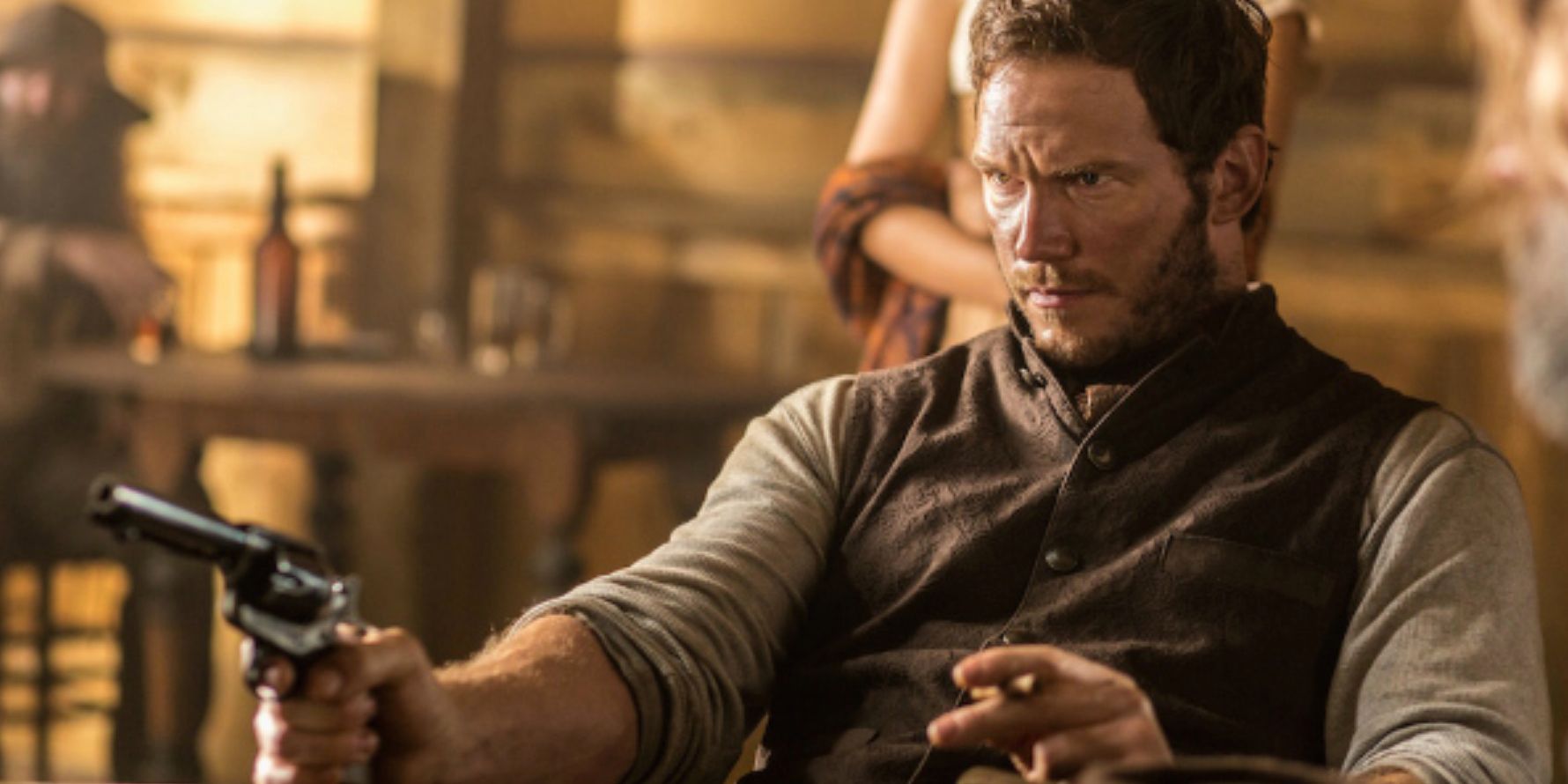 Chris Pratt As Joshua sitting with gun in The Magnificent Seven