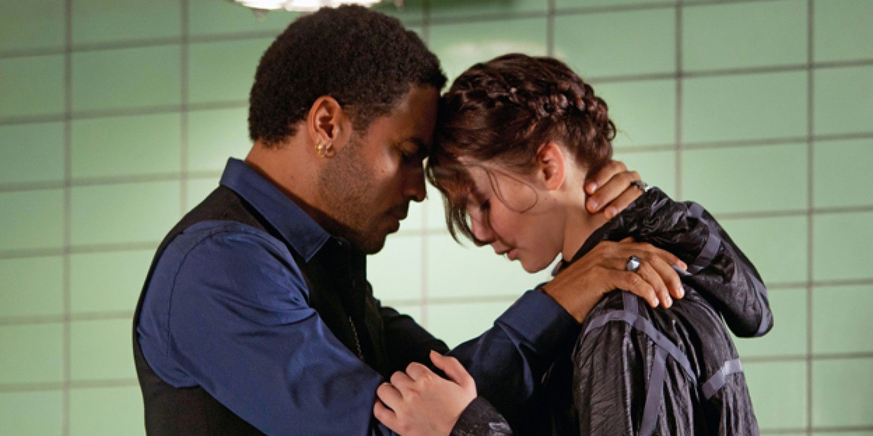 Cinna and Katniss leaning against one another before she has to go into the arena for the Hunger Games