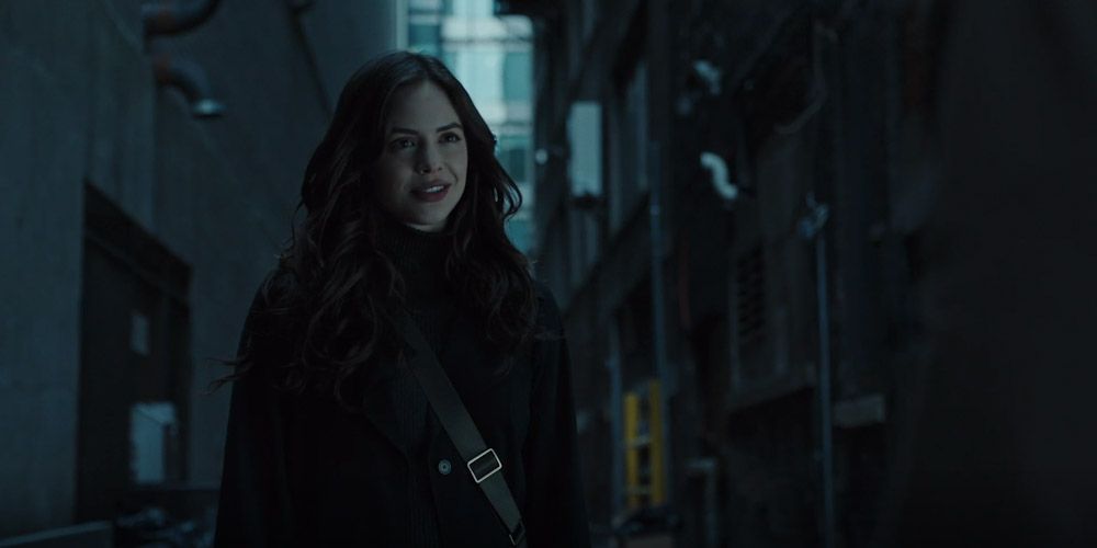 Donna Troy standin in a dark alley and smiling