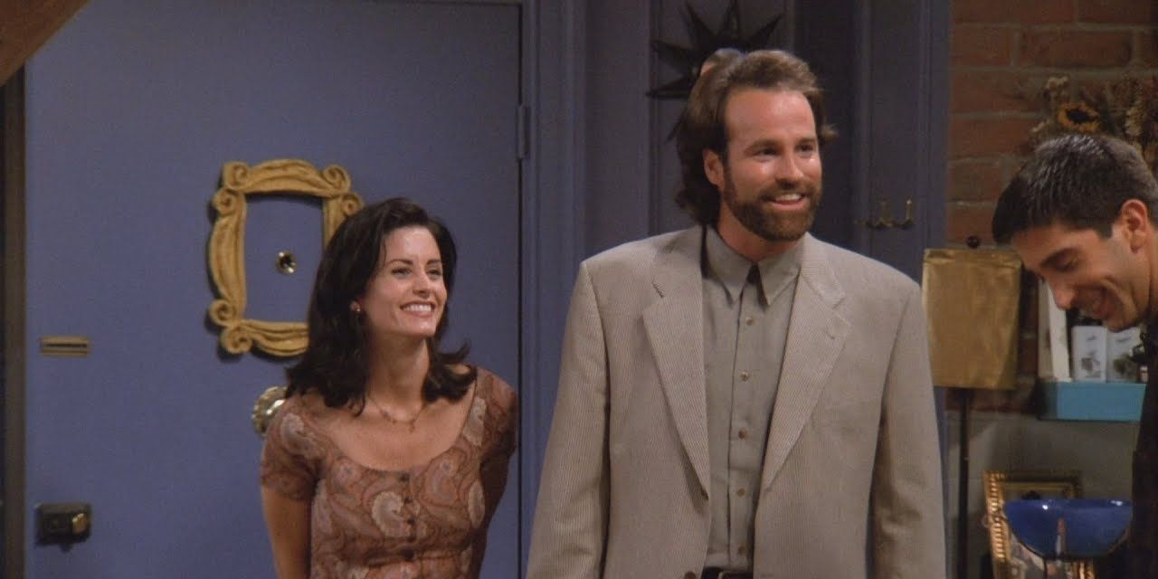 Monica and Alan standing together in the apartment on Friends