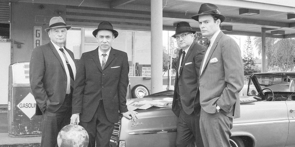 Several men pose in front of a car from Documentary Now!