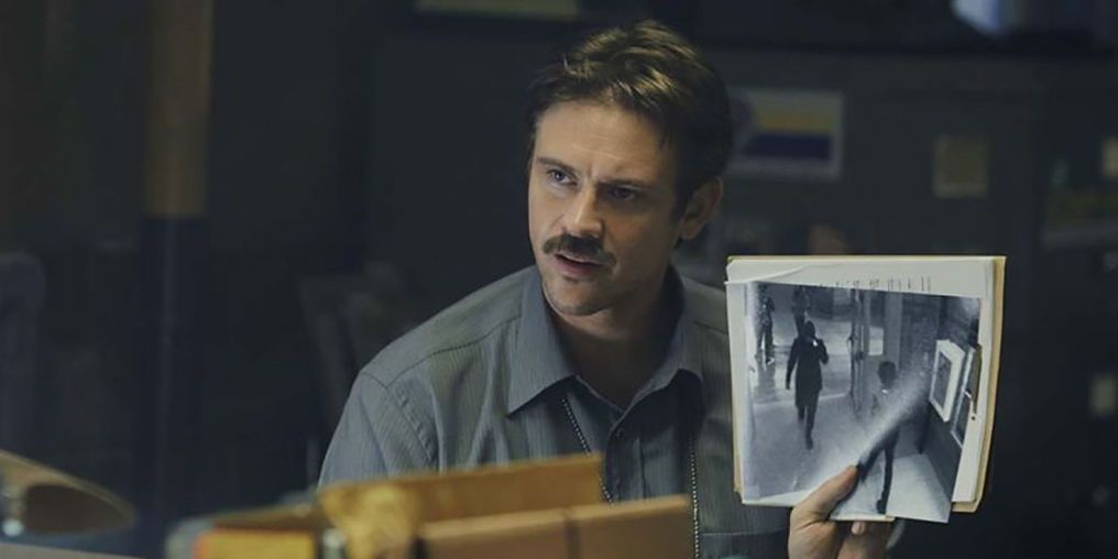 Boyd Holbrook holding up a picture in In the Shadow of the Moon