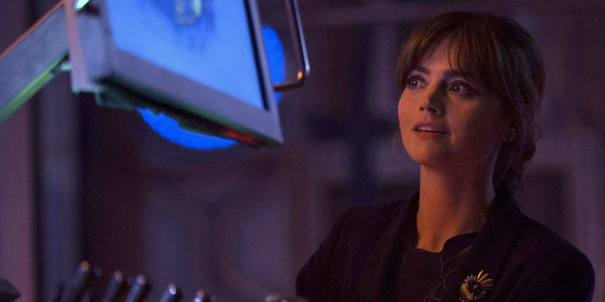 Clara smiling while looking at something in Doctor Who 