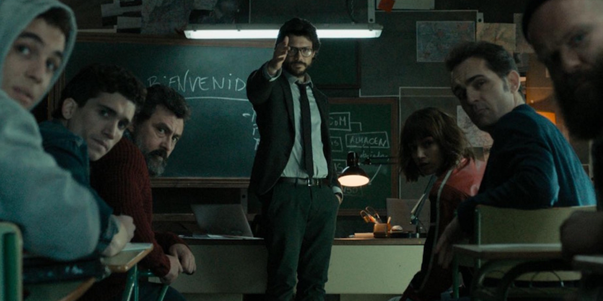 The Professor points down a hall as his team looks on in Money Heist
