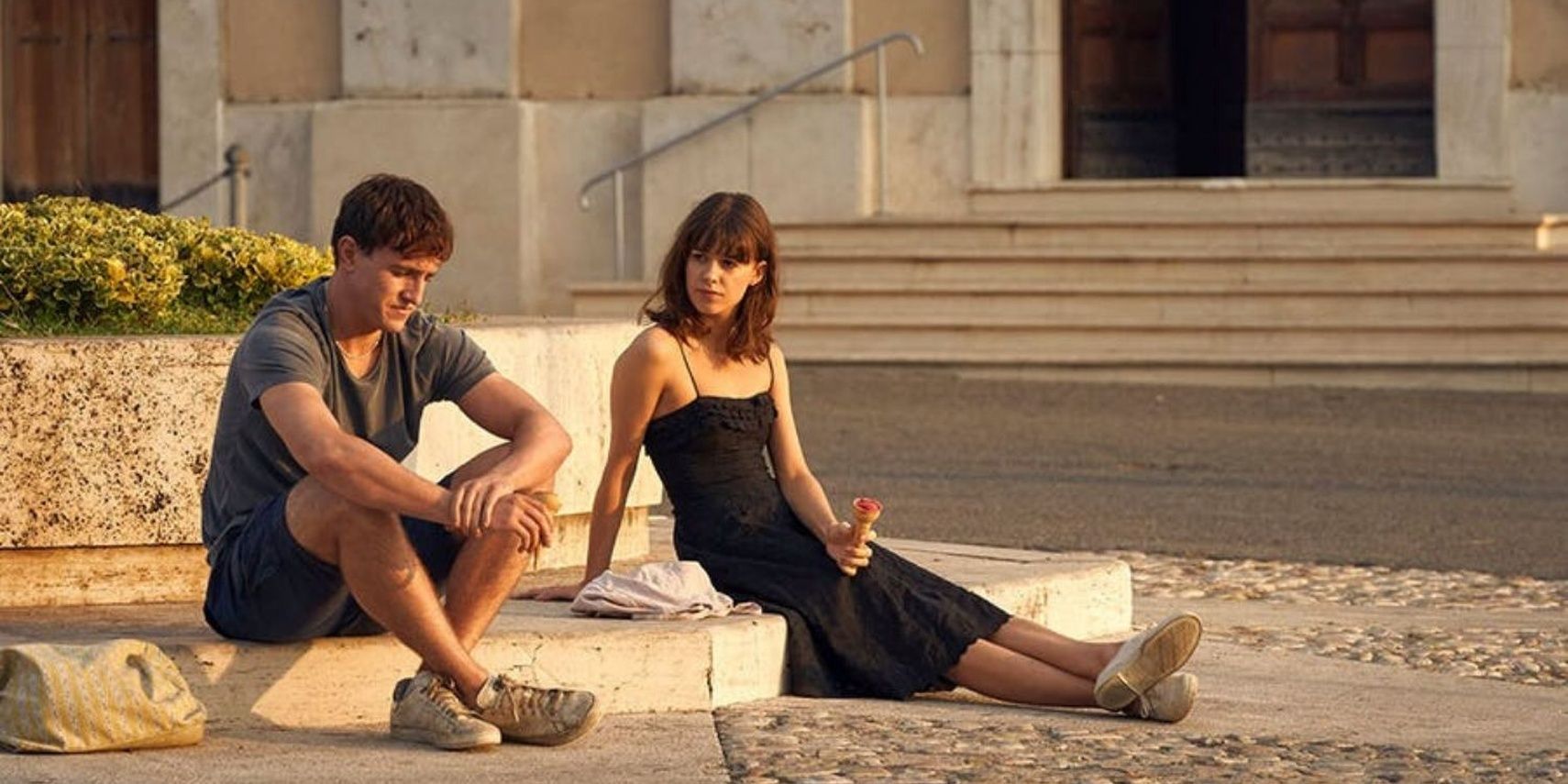 Marianne and Connell sitting on the sidewalk in Normal People