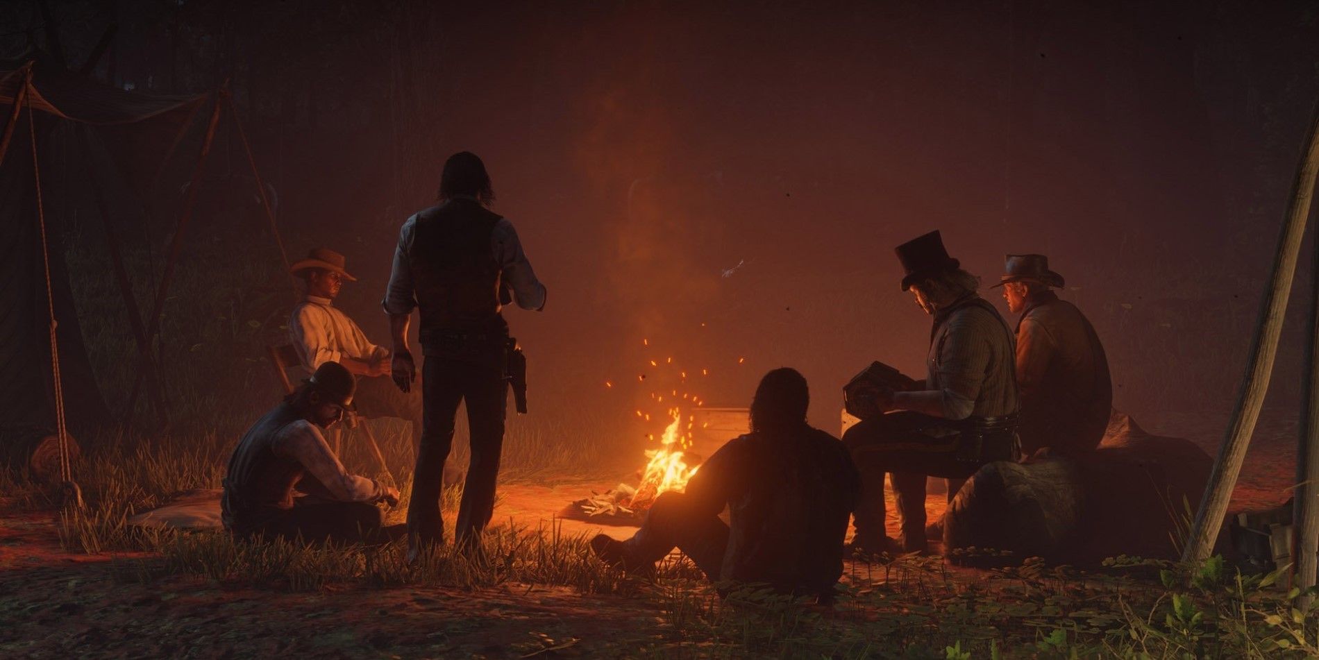 Membros de gangues sentados ao redor de uma fogueira em Red Dead Redemption 2