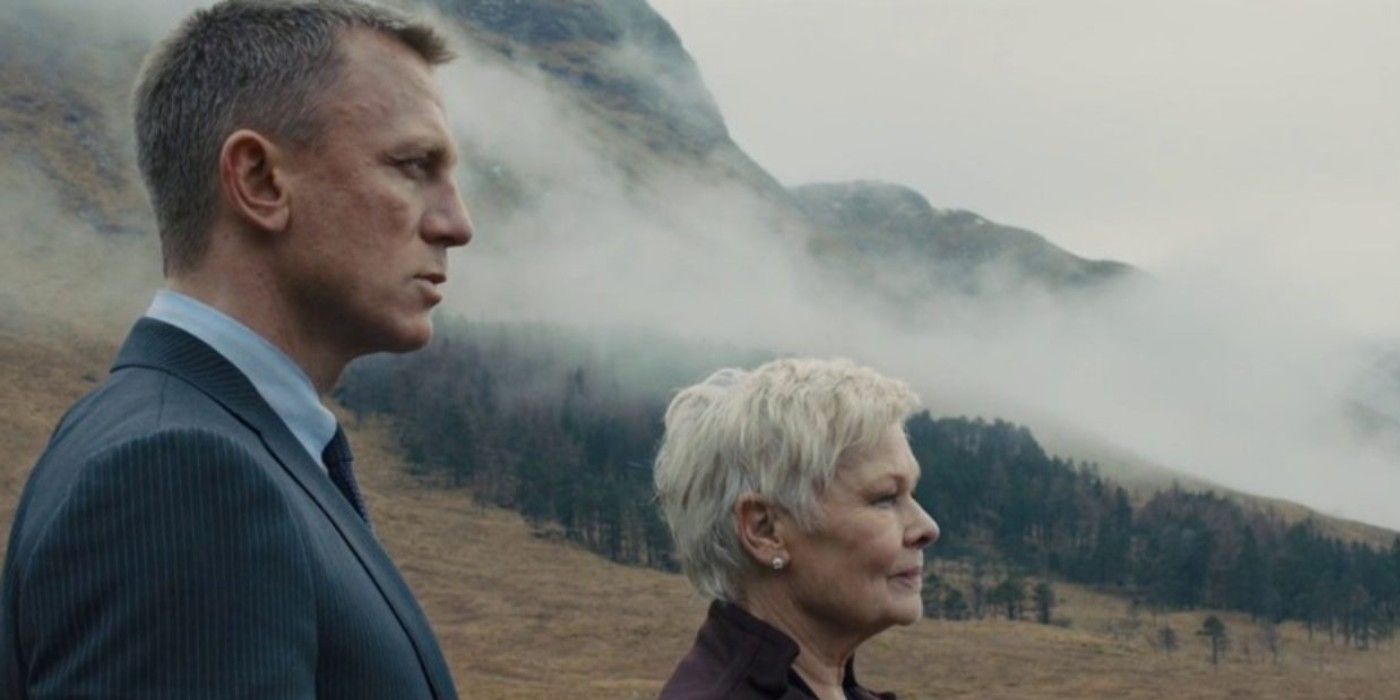 Judi Dench as M and Daniel Craig as James Bond standing on a hill in Skyfall