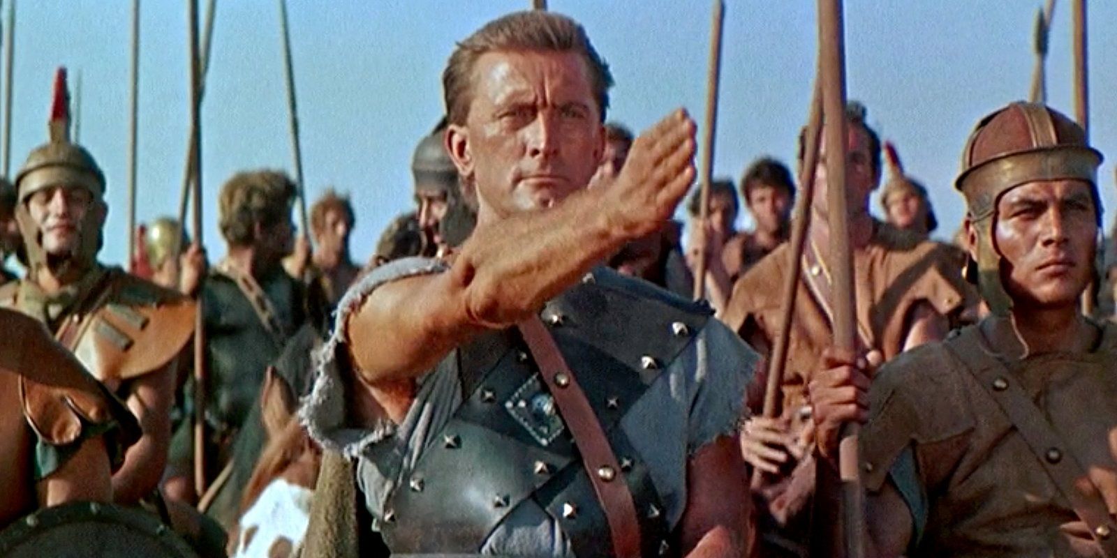 Spartacus gestures forward with his arm as soldiers stand behind him in Spartacus.